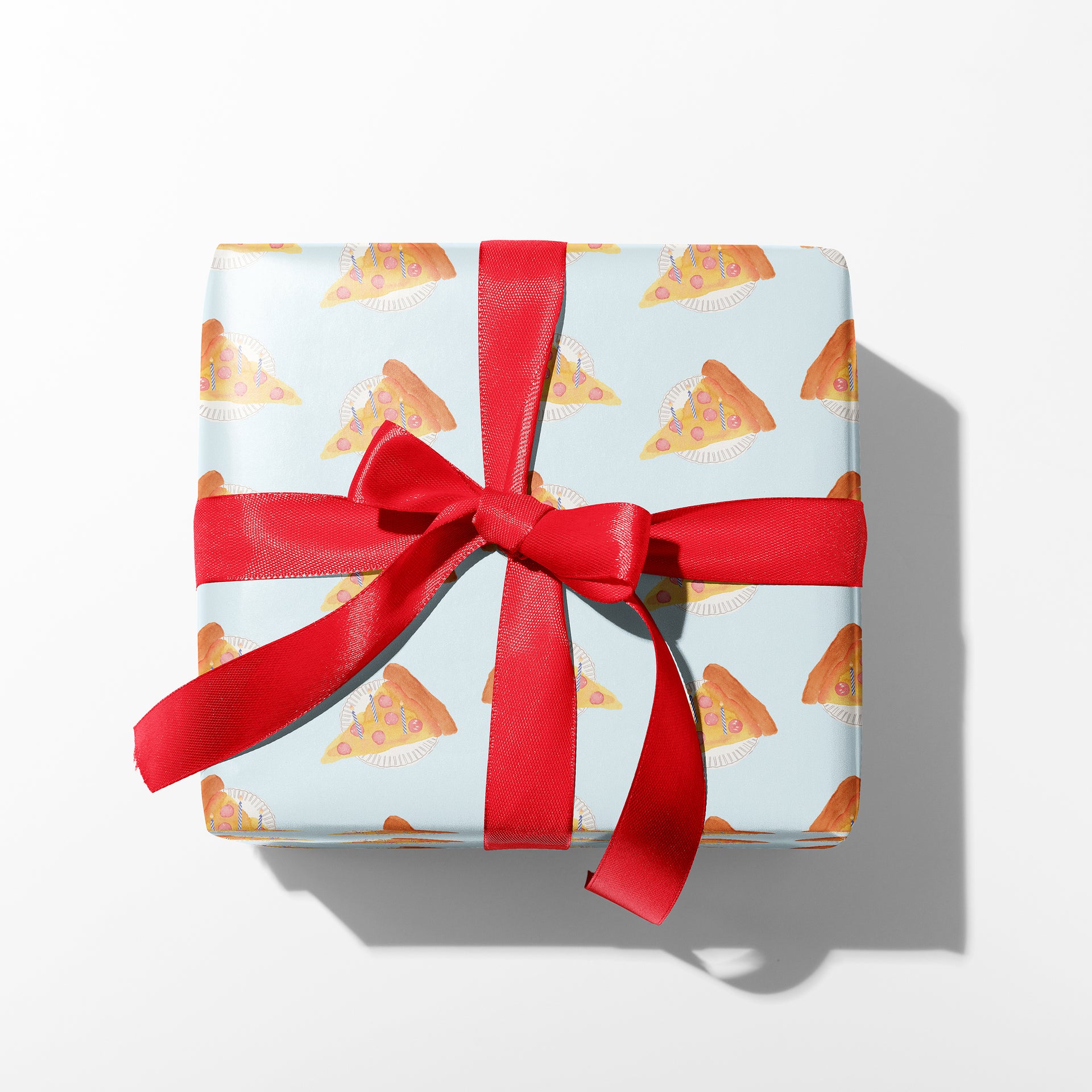 Gift box with pizza pattern and red ribbon on a white background