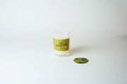 Candle with 'Dirty Martini' label on a white background