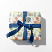 Gift box with construction-themed wrapping paper and a blue ribbon on a white background