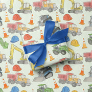 Gift with blue ribbon on construction-themed wrapping paper