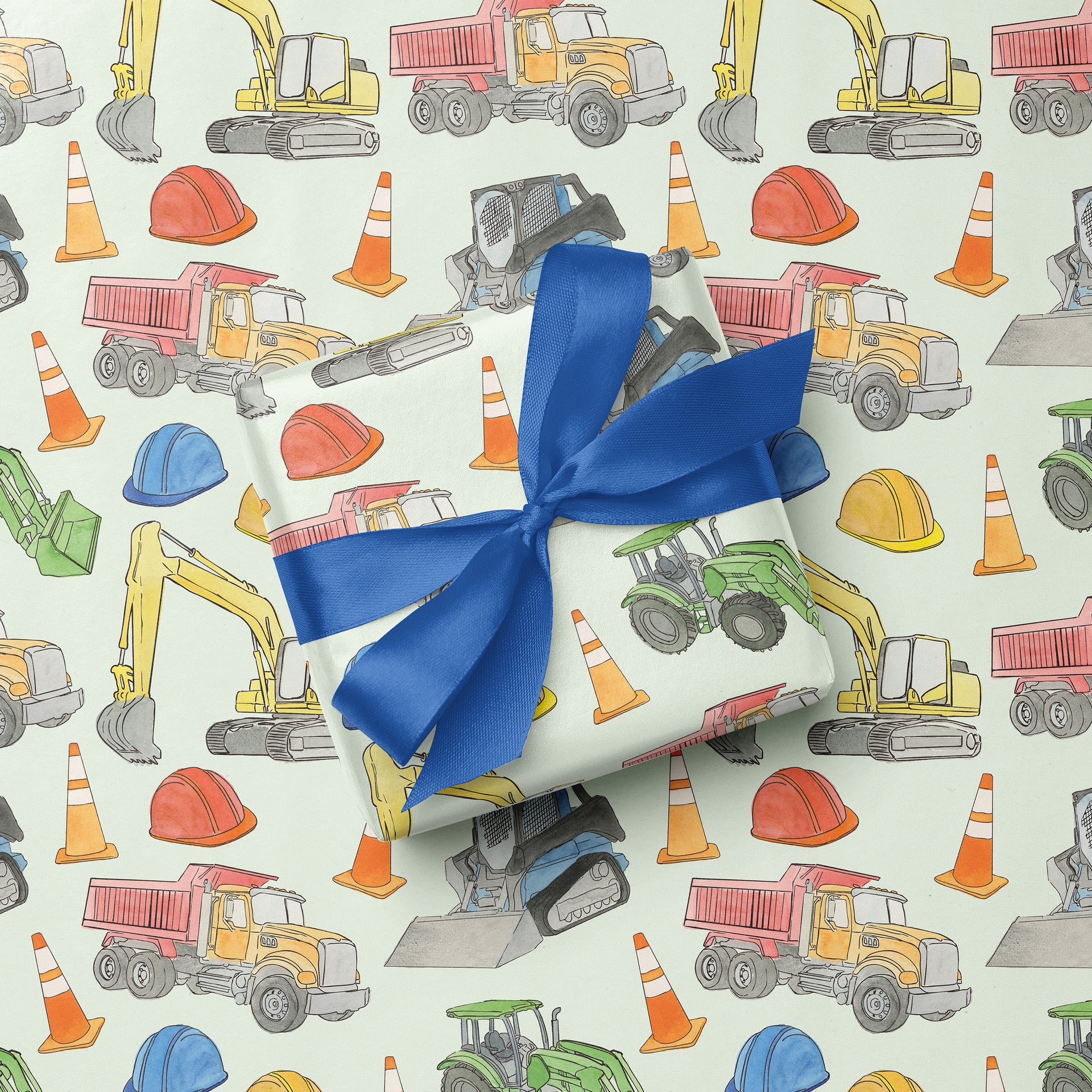 Gift with blue ribbon on construction-themed wrapping paper