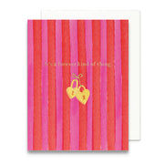 Greeting card with red and pink striped pattern and gold heart-shaped locks.
